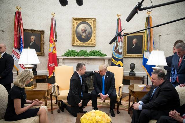 “请赐他力量吧。”一群牧师手搭手做仪式，好似汇聚能量，为特朗普祈祷